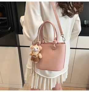 Borsa a secchiello rosa con trama litchi e ciondolo a orsetto in scena lifestyle