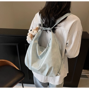 Vue arrière du sac à dos en cuir souple bleu clair avec pendentif ours pour l'école