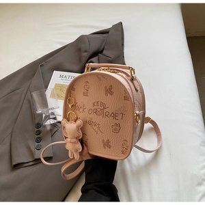 Detail of light pink mini backpack featuring vintage bear print and golden hardware