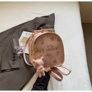 Pink mini backpack detail featuring bear prints, KEBU logo and plush charm accessory