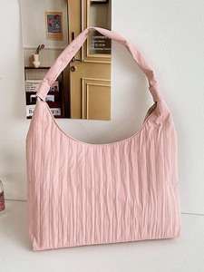Minimalist pink pleated hobo tote bag with a spacious shoulder design in a clean setting