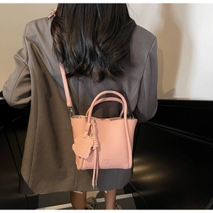 Détail du sac seau rose en cuir souple avec charm ours mignon et pampille sur le côté