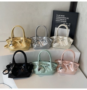 Bolsos tipo cubo en seis colores con colgantes de corazón y acabado perlado de moda