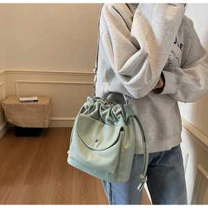 Détail du sac seau en toile vert menthe avec cordon de serrage et poche à rabat