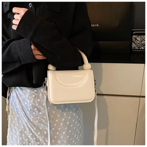 Detail of cream white mini square bag with glossy leather and unique sphere handle decor