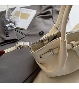 Nahaufnahme der cremefarbenen Ledertasche mit silbernen Beschlägen und Kordelzugverschluss
