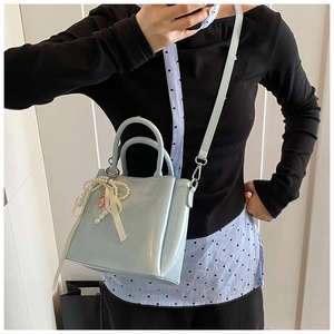 Mirror selfie showing the scale of the light blue bucket bag with pearl and ribbon charm