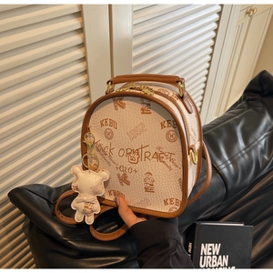 Detailed view of the bear illustration and textured leather on the chic cream backpack