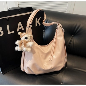 Détail du sac cabas en cuir rose souple avec bandoulière et breloque ours en peluche