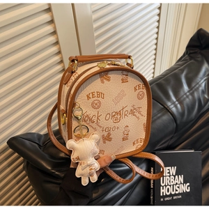 Close-up of retro letter print texture and teddy bear pendant on beige backpack