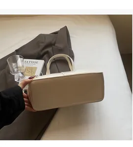Detail showing high-quality synthetic leather texture and flat bottom of the cream tote bag