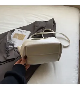Detail einer cremeweißen Beuteltasche aus weichem Leder mit flachem Boden und viel Stauraum