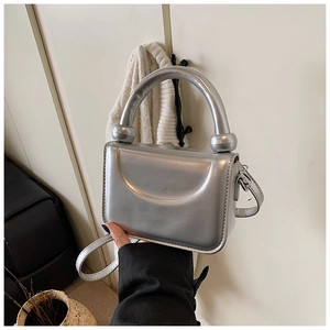 Detailed view of mini silver leather bag with metallic mirror finish and sleek top handle
