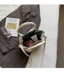 Details der Innenkapazität der weißen Lederbeuteltasche mit Gegenständen des Alltags