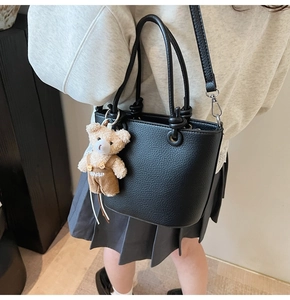 Borsa a secchiello in pelle litchi nera con ciondolo a forma di orso indossata da modella