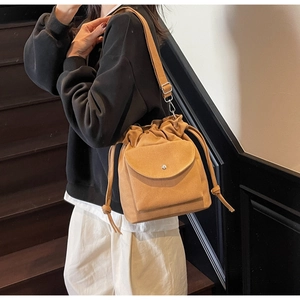 Vue détaillée du sac seau marron à cordon avec poche avant à rabat et boucle métallique