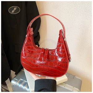 Dettaglio borsa hobo rossa con rilievo coccodrillo, zip argentate e finitura lucida
