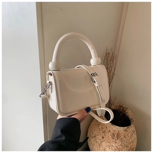 Minimalist creamy white square bag with thick handle and adjustable crossbody strap