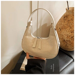 Dettaglio della borsa croissant bianco sporco con trama coccodrillo e cerniere argento