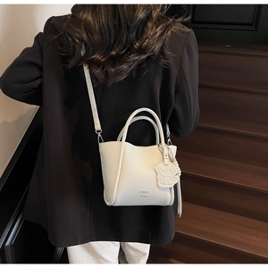 Gros plan du mini sac blanc en cuir texturé avec logo embossé et charmant petit ours