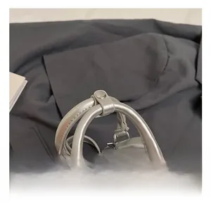 Detail of silver metallic handbag showing dual top handles and premium metal zippers