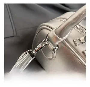 Detail of silver metallic leather bag showing polished metal hook and fine texture