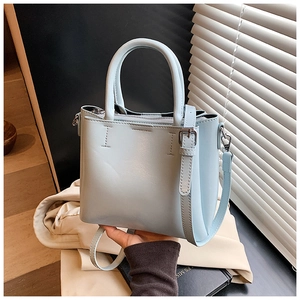 Close-up of light blue bucket bag showing matte leather texture and silver zipper detail