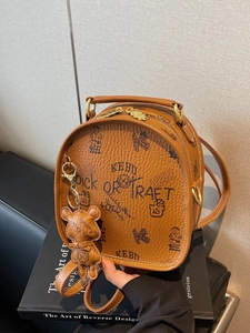 Caramel brown pebbled leather mini backpack with bear charm and chic printed design