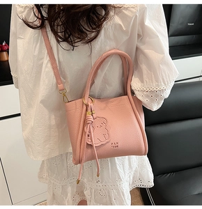 Pink lychee grain leather bucket bag with bear embossing and tassel detail