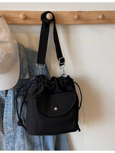 Sac seau minimaliste en toile noire avec cordon de serrage et bandoulière réglable