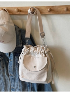 Sac seau minimaliste en toile beige avec cordon de serrage et bandoulière réglable