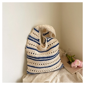 Gros plan de la texture en maille ajourée du sac cabas rayé bleu et crème