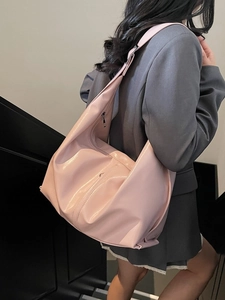 Pink glossy leather Hobo tote bag with wide strap worn by model in stair setting