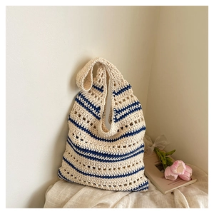 Détail du sac cabas rayé bleu en paille tressée avec texture en maille ajourée