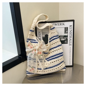 Détail du sac fourre-tout tissé à rayures avec un grand nœud en mesh et broderie rose