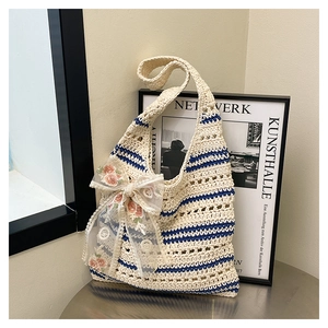 Détail d'un sac cabas tissé avec rayures bleues et un nœud en dentelle florale