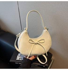 Détail du sac croissant blanc crème avec finition mate et décoration de nœud