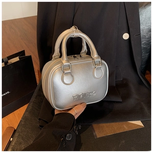 Detail of silver retro handbag featuring embossed RETRO text and metallic leather finish