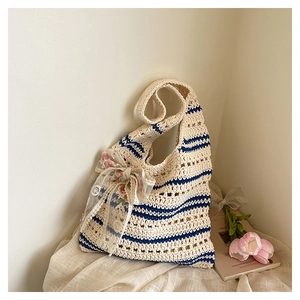 Gros plan du sac fourre-tout tissé avec motifs géométriques et nœud en dentelle florale