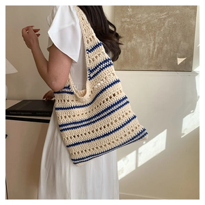 Détail d'un sac cabas crocheté à la main avec rayures bleues et motifs en maille ajourée