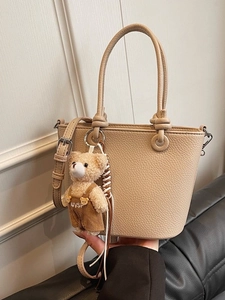 Borsa a secchiello color albicocca con motivo litchi e ciondolo orsetto alla moda