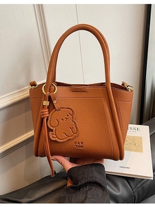 Brown litchi grain leather tote bag with PANTOR logo and cute dog charm ornament