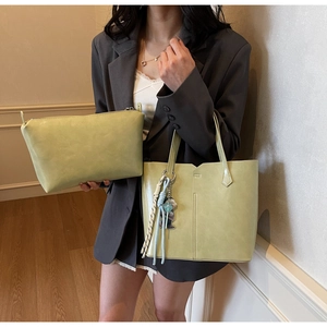Detail view of light green tote bag set with matching zipper pouch on model