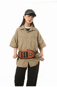 Close-up of bright orange waterproof chest bag with black straps on a male model