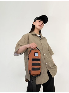 Detail view of brown tactical crossbody bag with MOLLE webbing and colorful logo detail