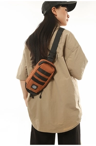Close-up of caramel brown sling bag showing durable nylon fabric and black webbing details