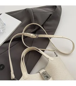 Detail of woven fabric bucket bag with silver twist lock and adjustable strap