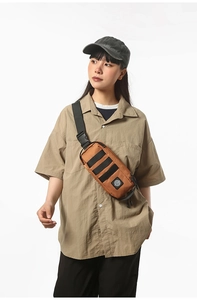 Detailed view of tactical chest bag showing MOLLE webbing system and brand logo on brown fabric