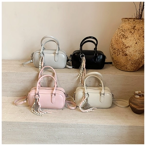 Sacs bowling minimalistes en gris, noir, rose et beige avec des pendentifs tressés