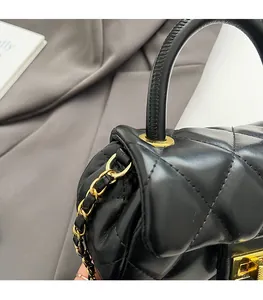 Dettaglio della borsa in pelle nera trapuntata con finiture in metallo dorato e catena